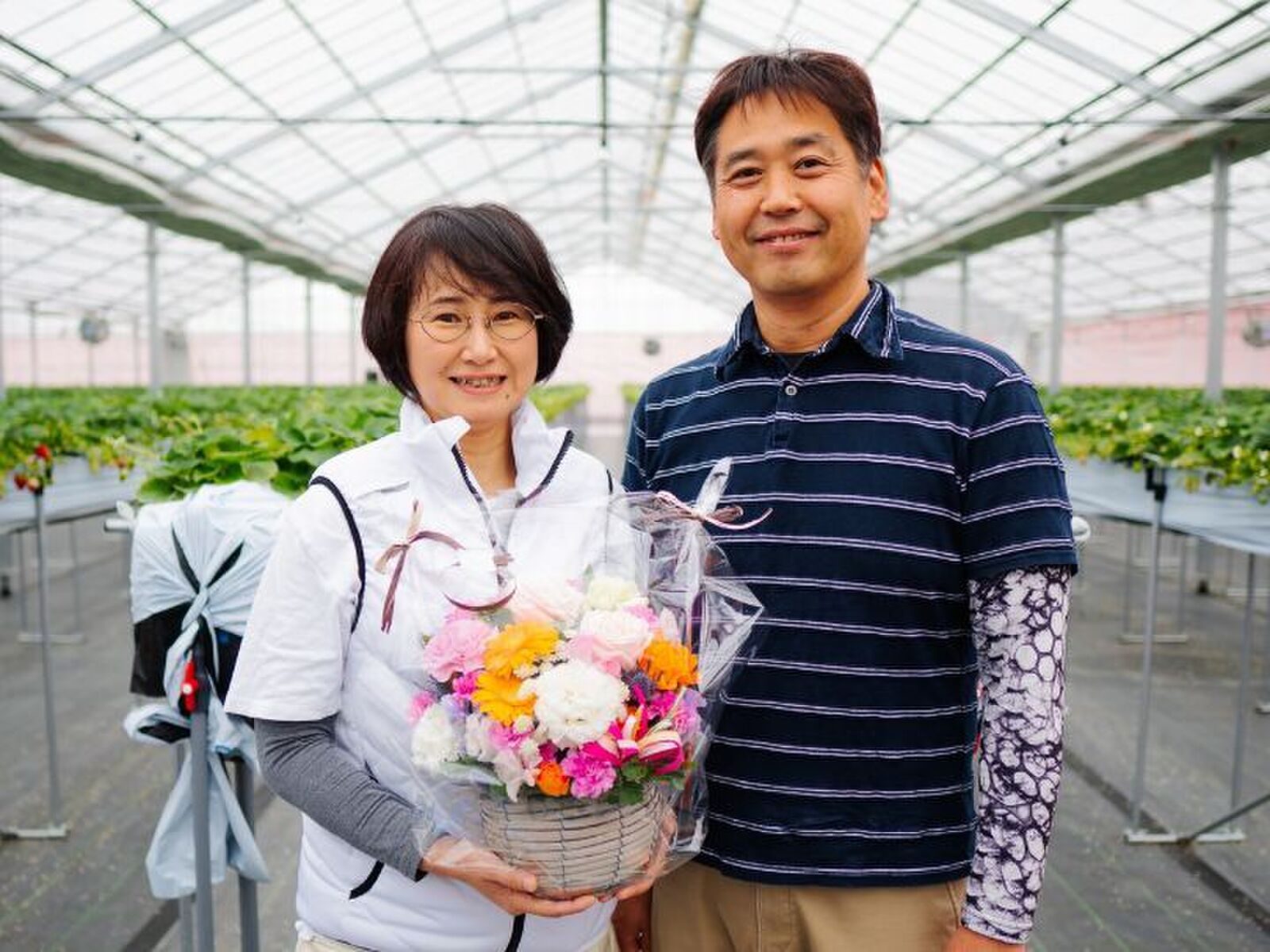 いちごハウスの中で花束を手に並ぶ、山元ヒルズファームの二人